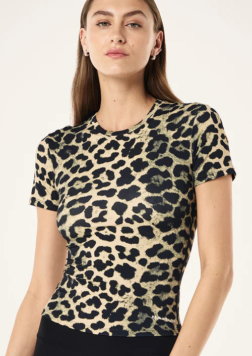 Woman wearing a leopard print top against a plain background