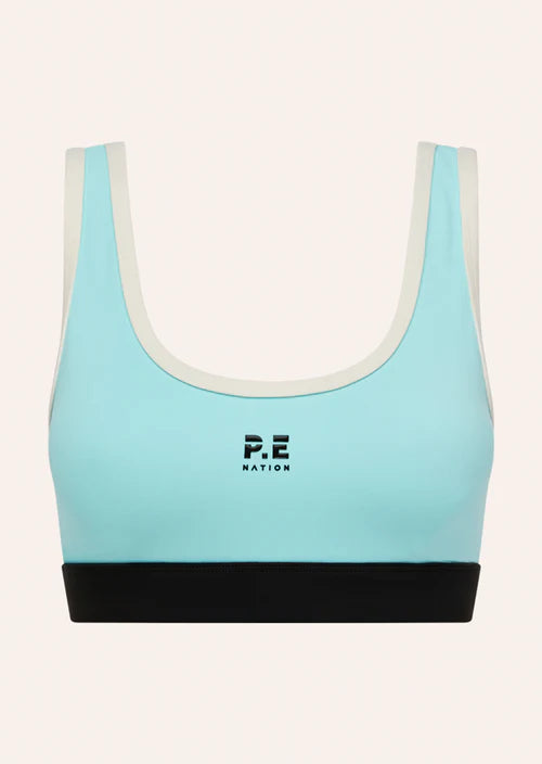 Light blue sports bra with black band and white trim on a white background, featuring 'P.E Nation' logo.