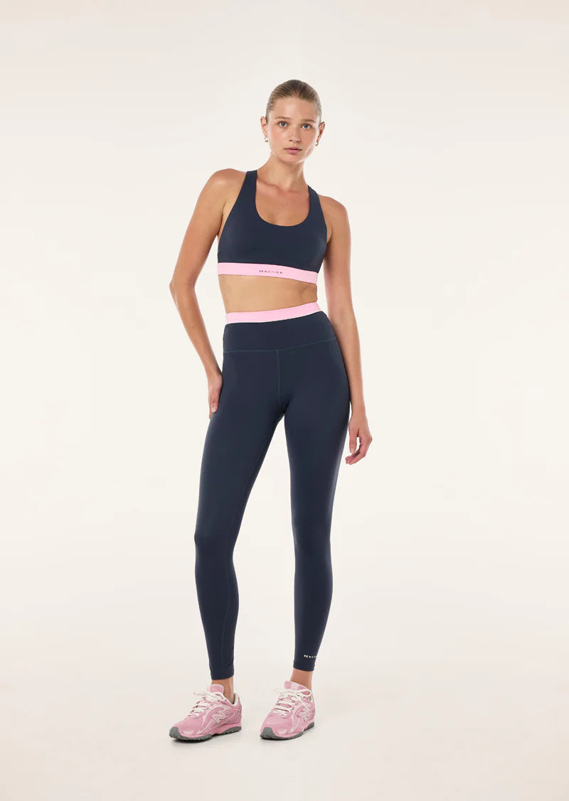 dark blue leggings with a pink waistband on a female model