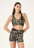 Woman wearing a leopard print sports bra and shorts on a white background