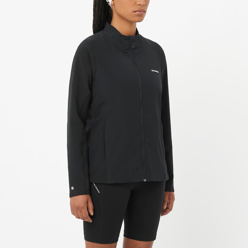Person wearing a black jacket and shorts on a white background