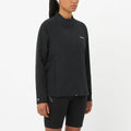Person wearing a black jacket and shorts on a white background