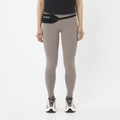 Person wearing beige leggings with a black waist bag on a white background