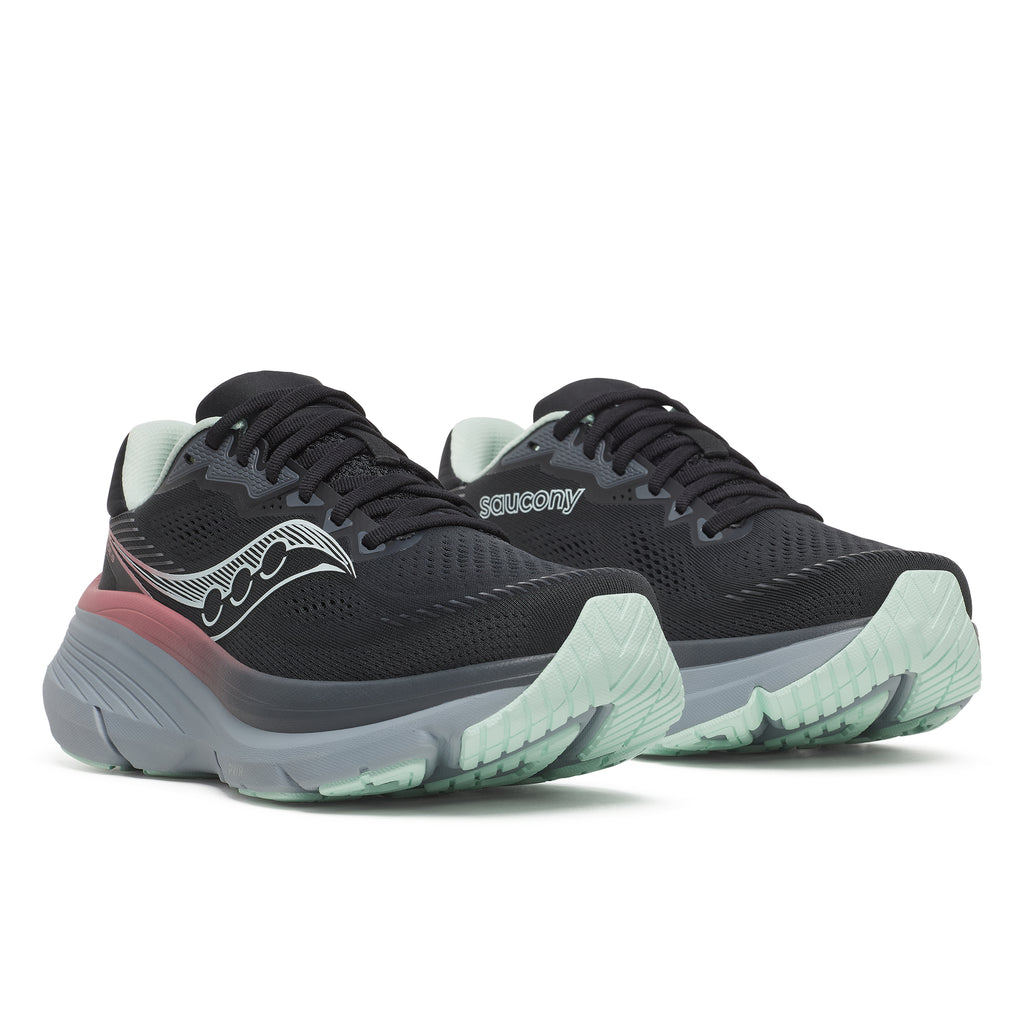 Black running shoes with green soles on a white background