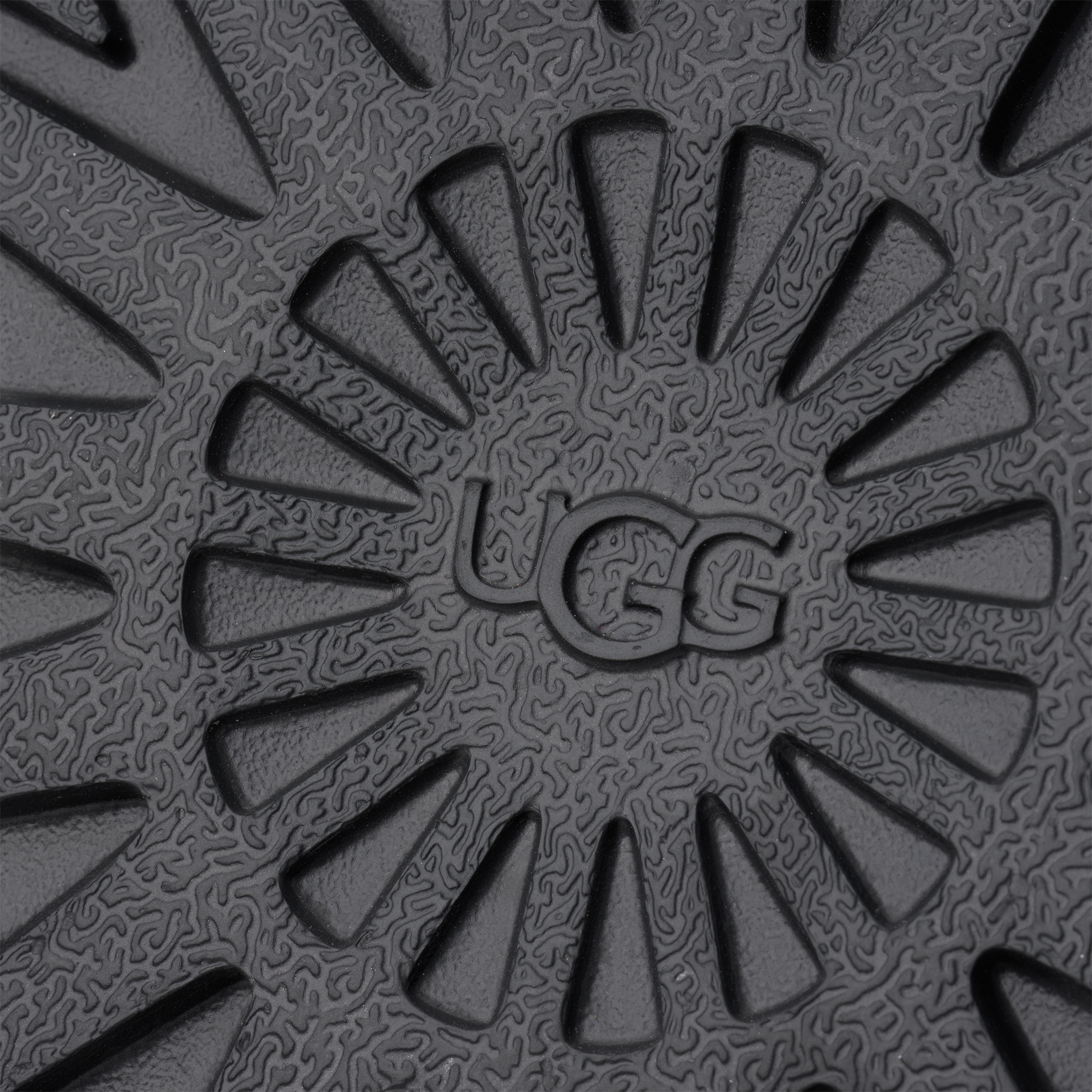 Close-up of a textured black mat with 'UGG' branding.