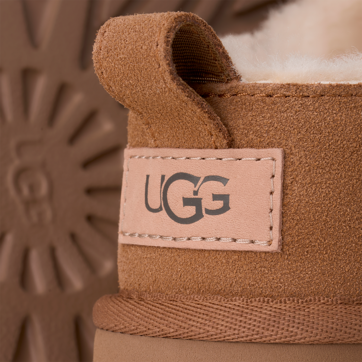 Close-up of a UGG boot with the brand logo on a brown background
