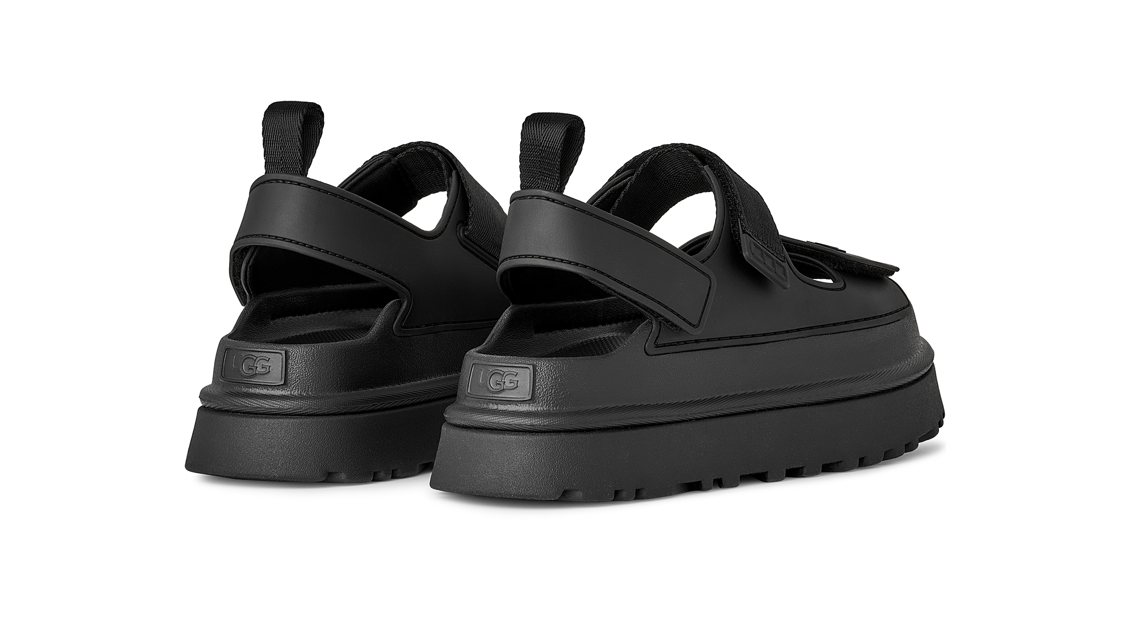 Black UGG sandals with thick soles on a white background