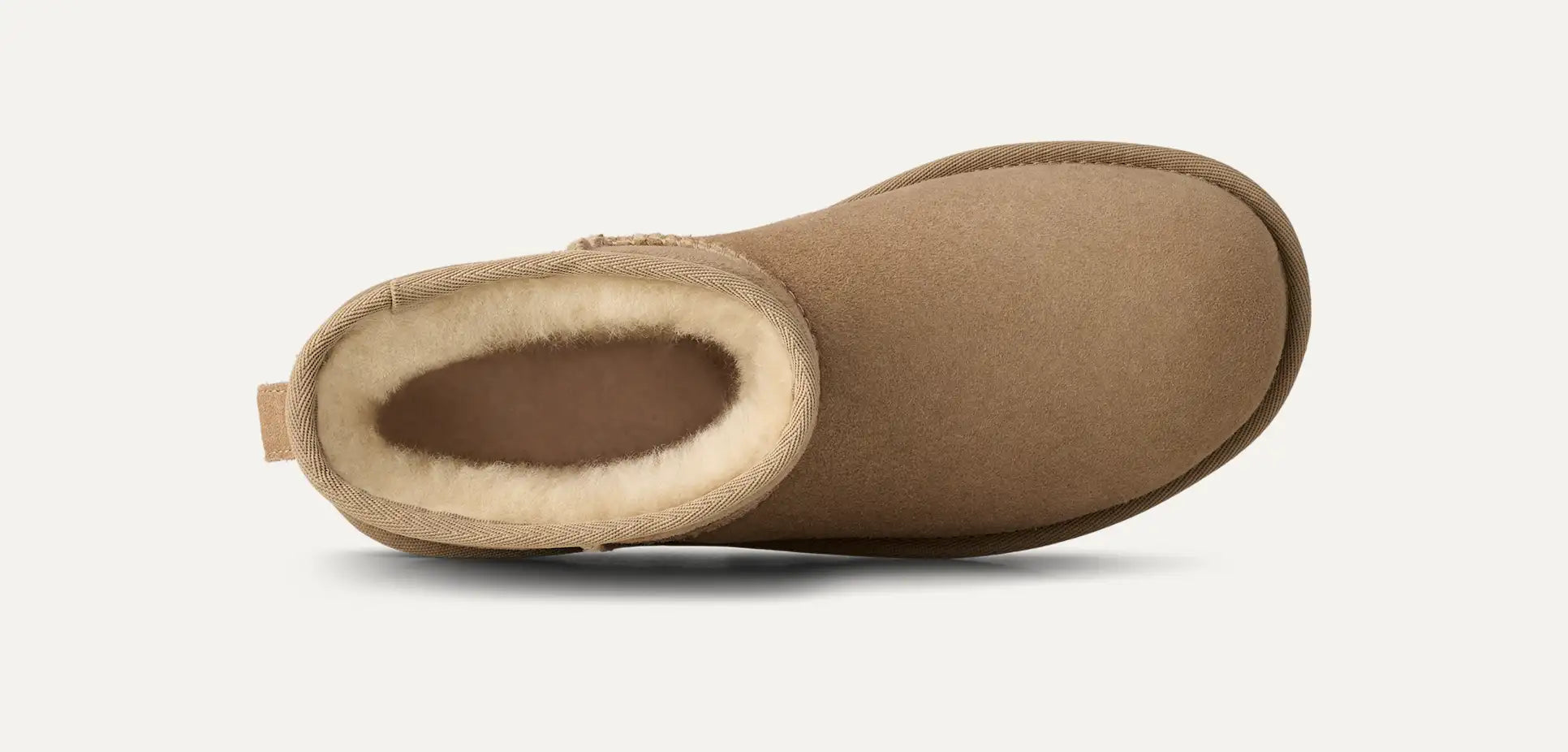 Sand coloured suede boot with beige fur lining on a white background