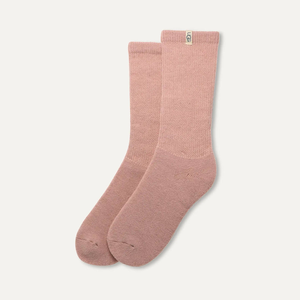 Pair of pink UGG socks on a light gray background