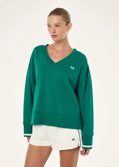 Woman wearing a green sweatshirt with a logo on a white background