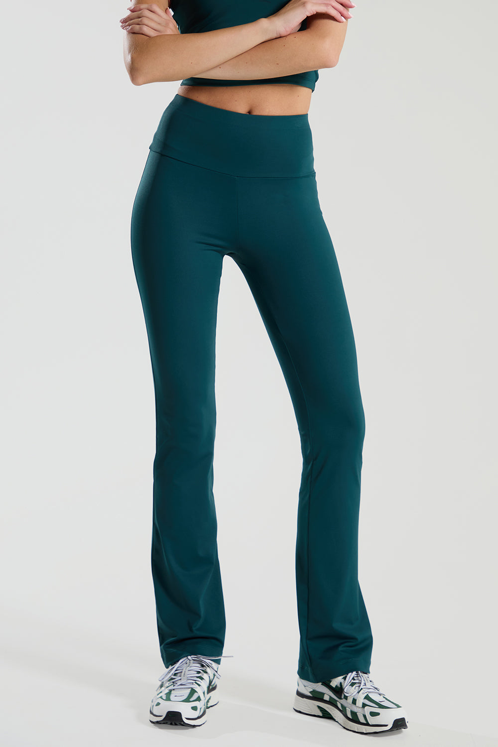 Person wearing teal green red run athletic pants on a white background