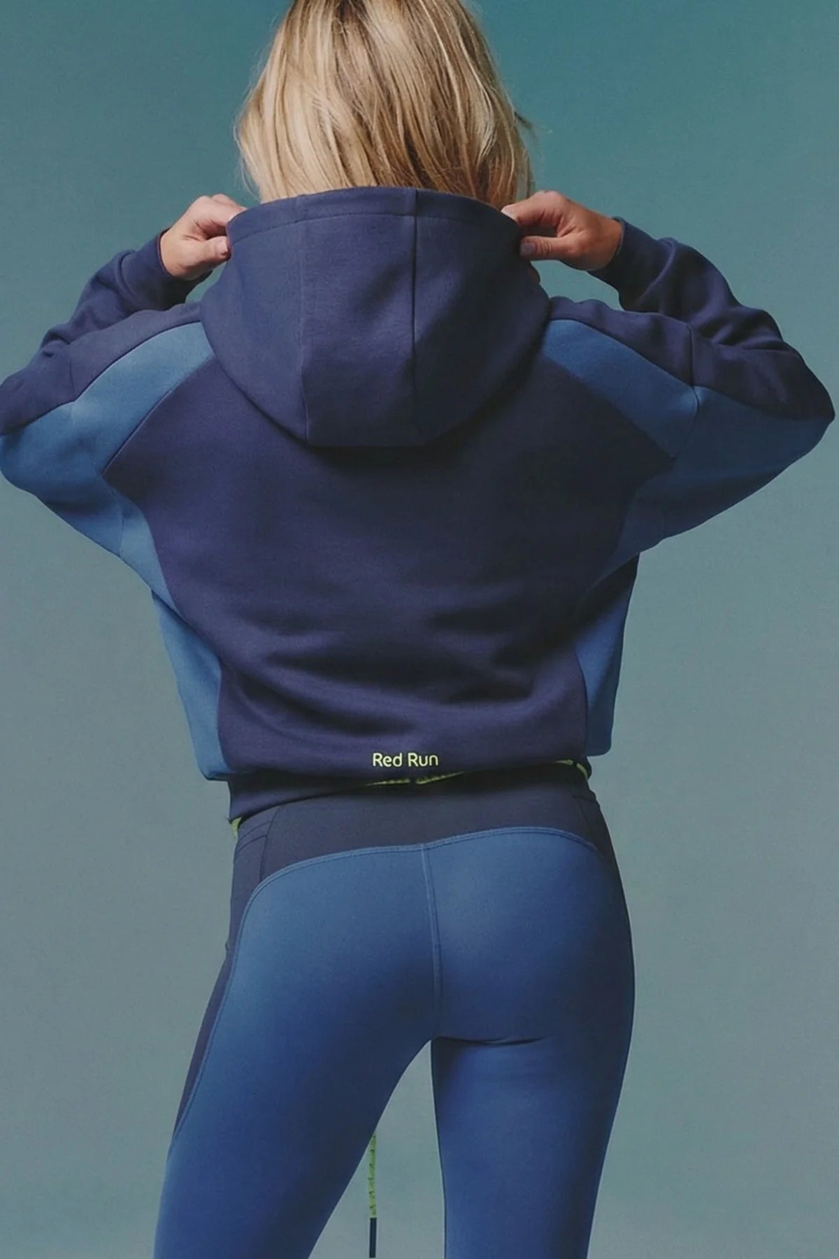 Person wearing a blue and purple hoodie with 'Red Run' branding on a solid background