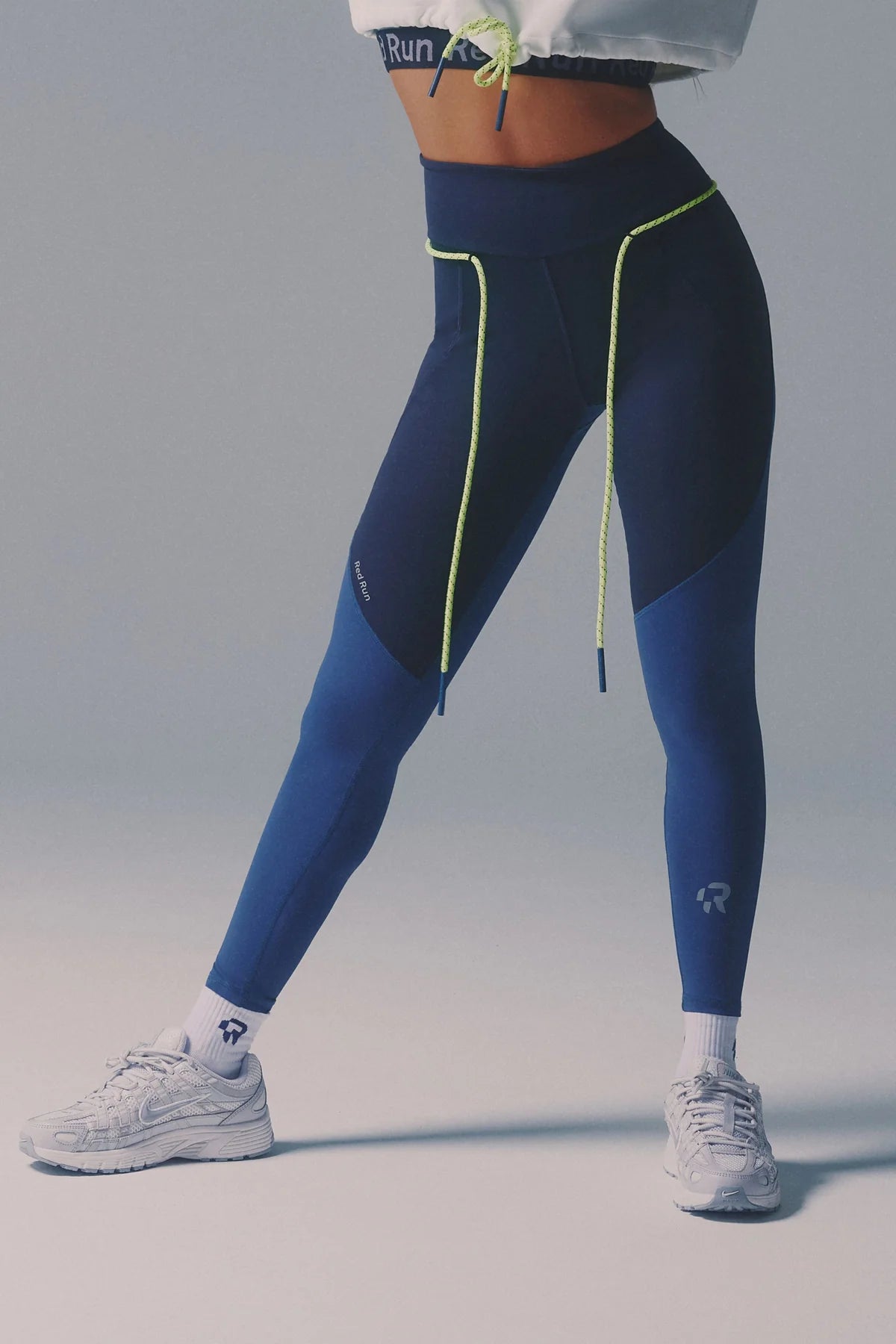 Person wearing blue and black leggings with a gray background