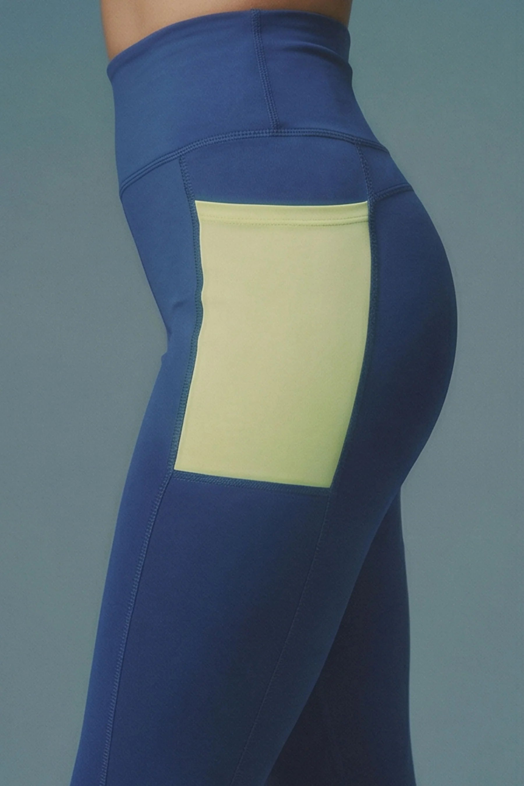 Blue leggings with a yellow patch on a gray background