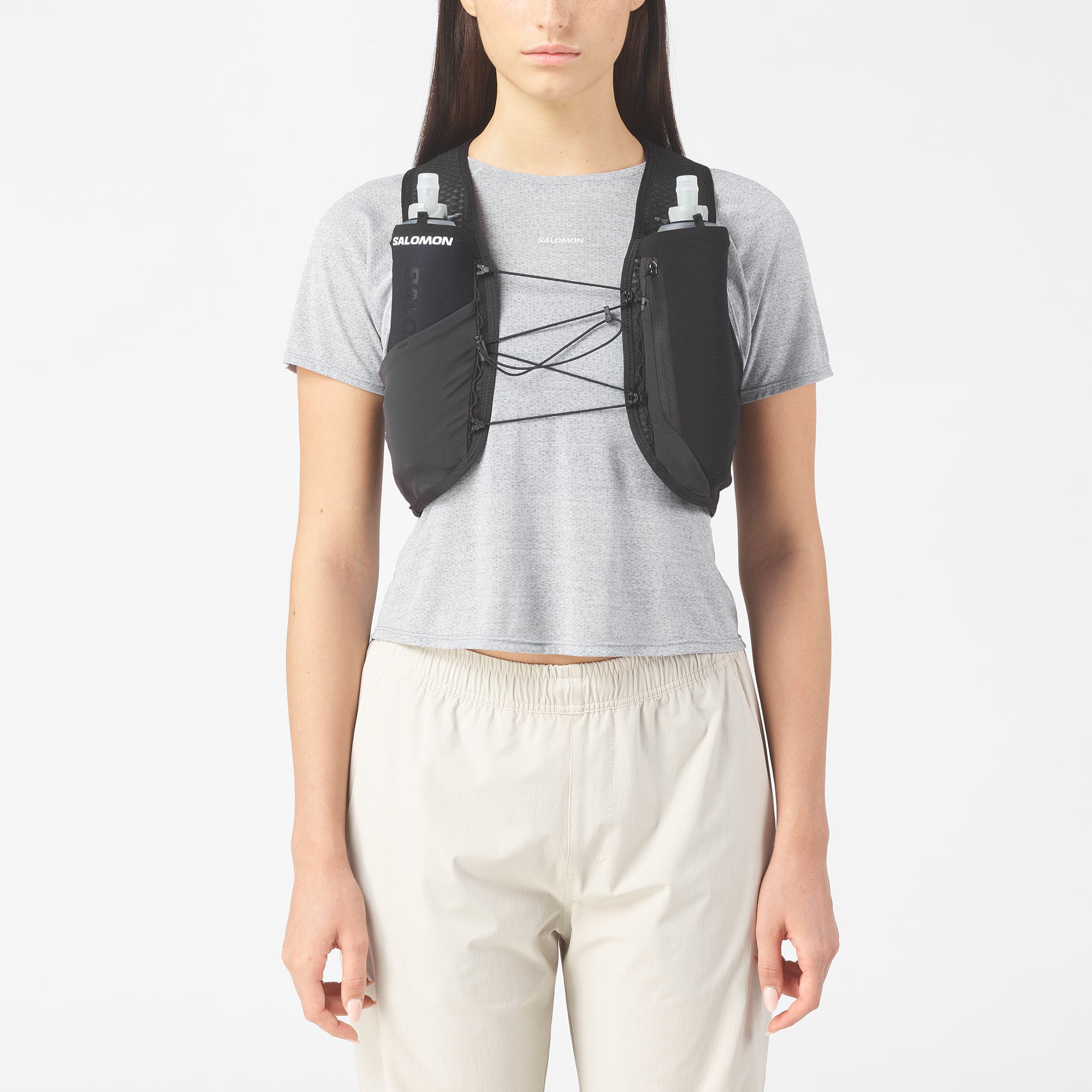 Person wearing a black and gray Salomon backpack  on a white background