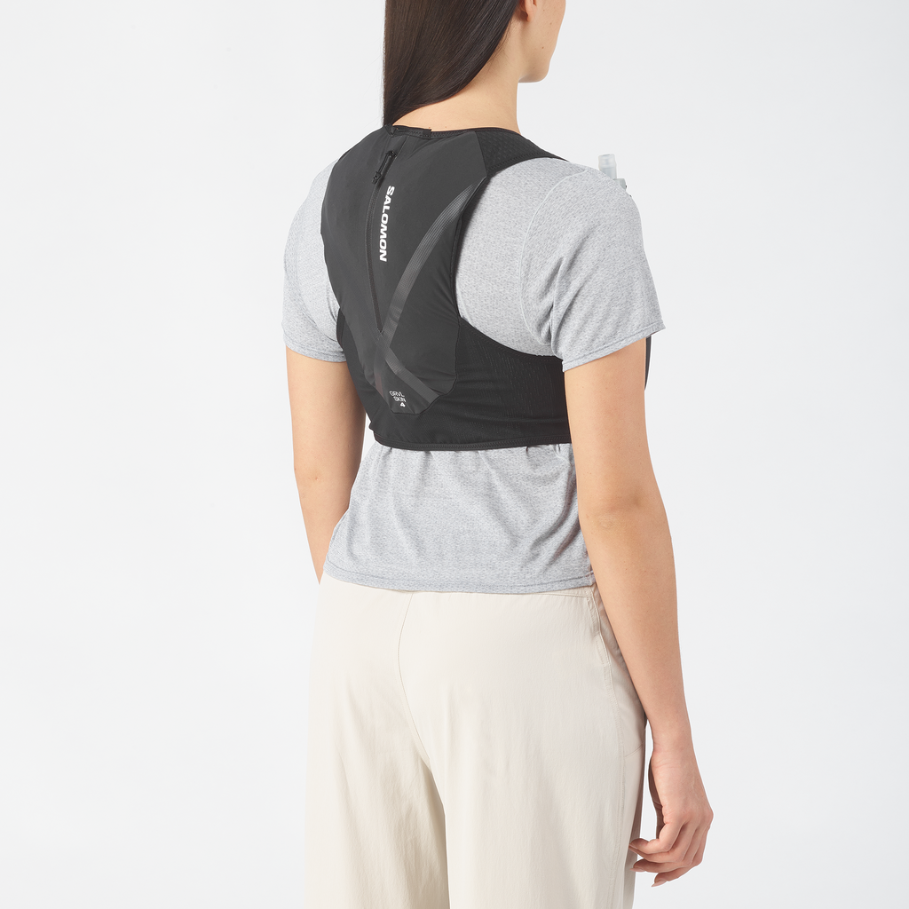 Person wearing a black backpack  with 'Salomon' branding on a white background