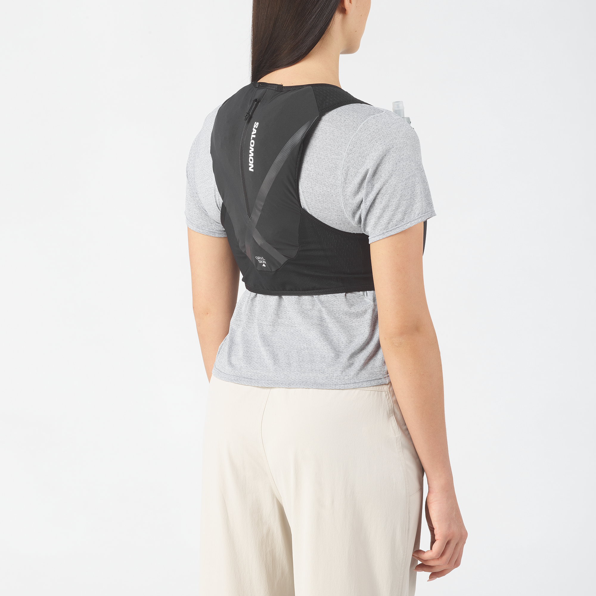 Person wearing a black backpack  with 'Salomon' branding on a white background