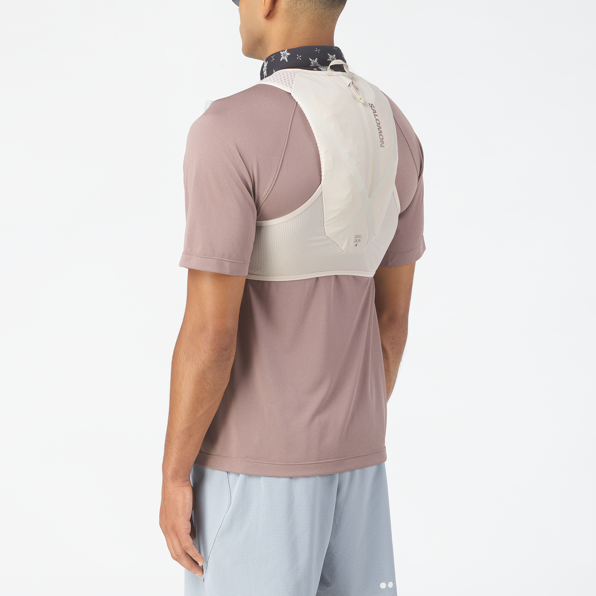 Person wearing a T shirt with a Salomon  hydration backpack on a white background
