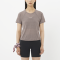Woman wearing a gray athletic shirt and black shorts on a white background