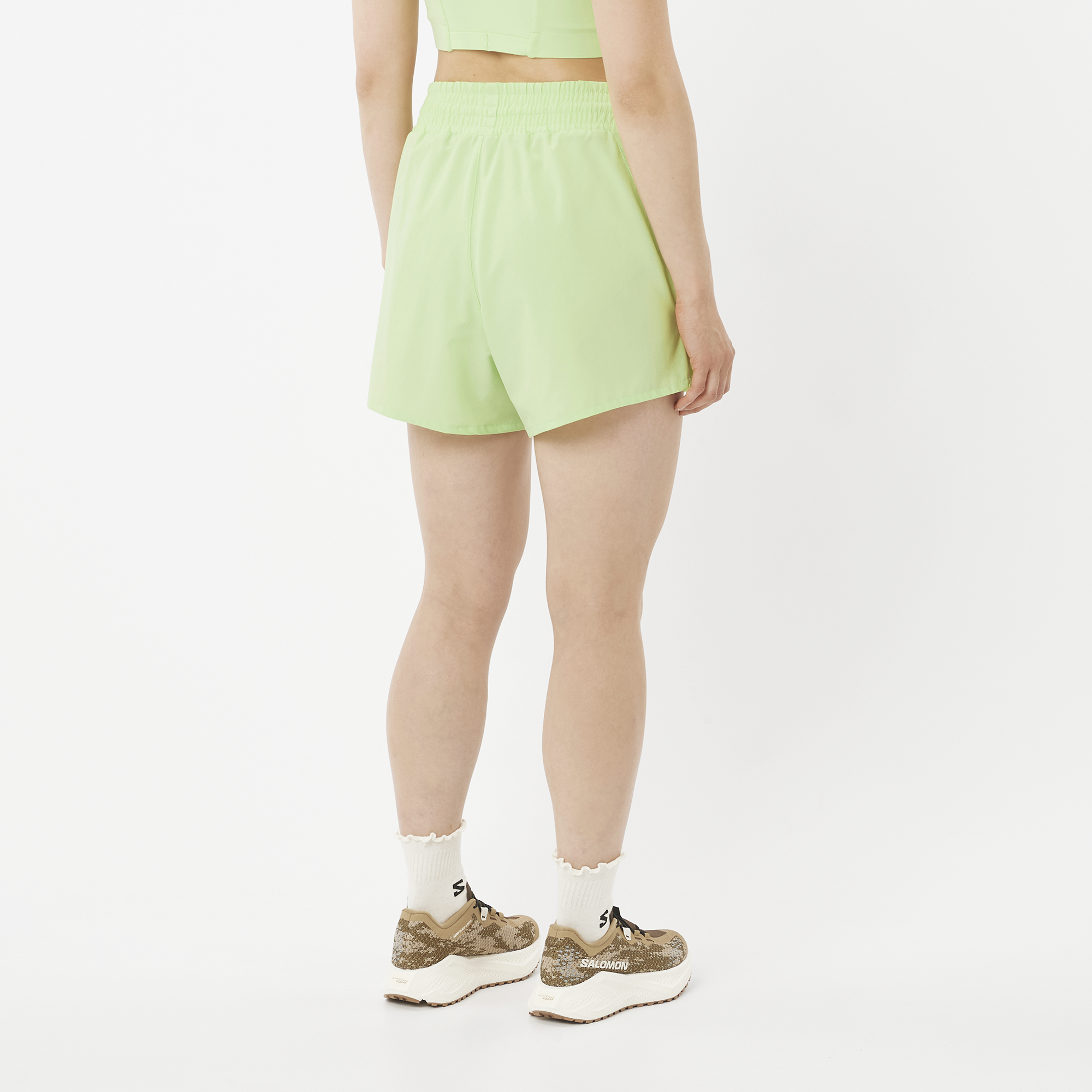 Person wearing light green shorts on a white background