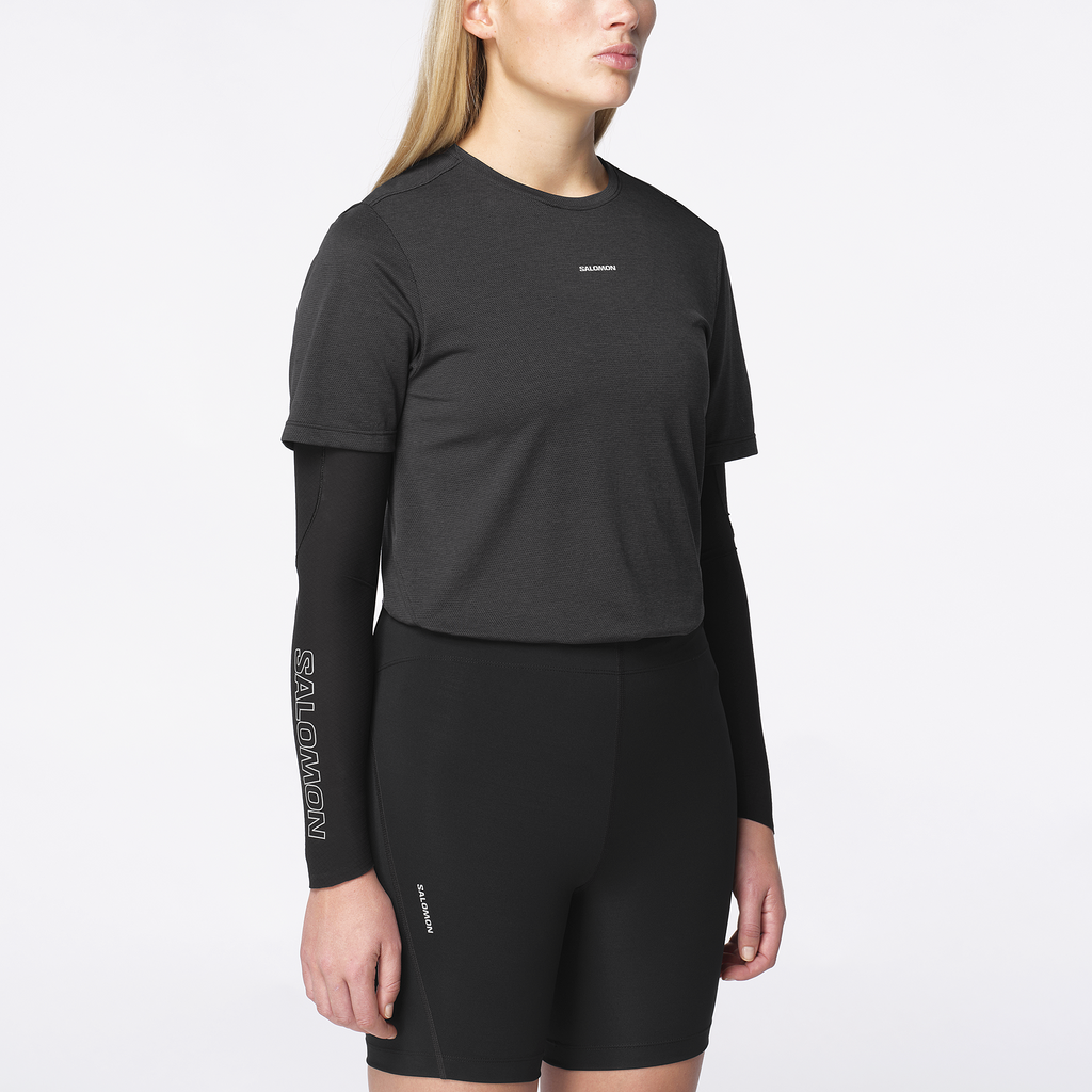 Person wearing a black Salomon athletic outfit on a white background