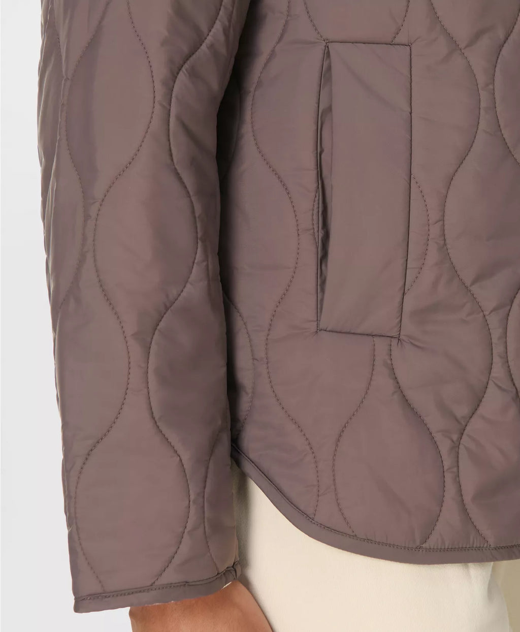 Close-up of a brown quilted jacket with a plain background