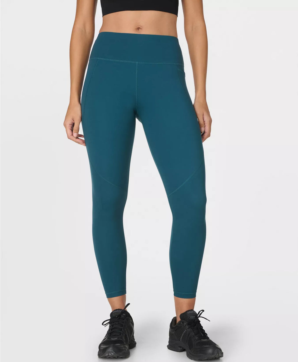 Teal leggings worn by a person on a white background