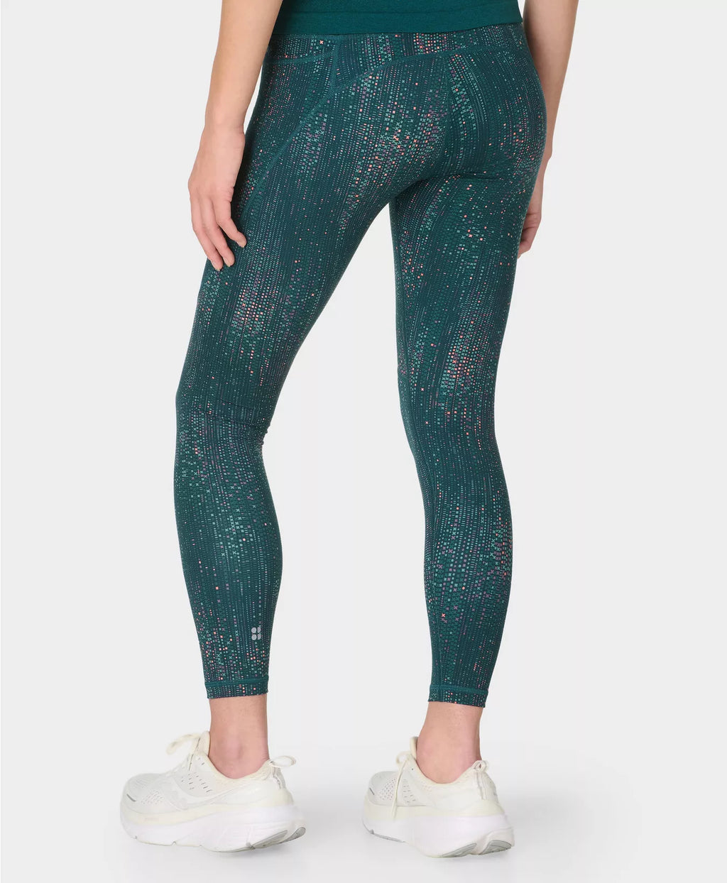 Person wearing teal patterned leggings on a white background