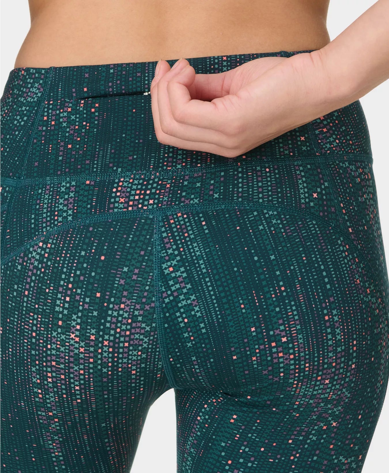 Teal patterned leggings worn by a person on a white background
