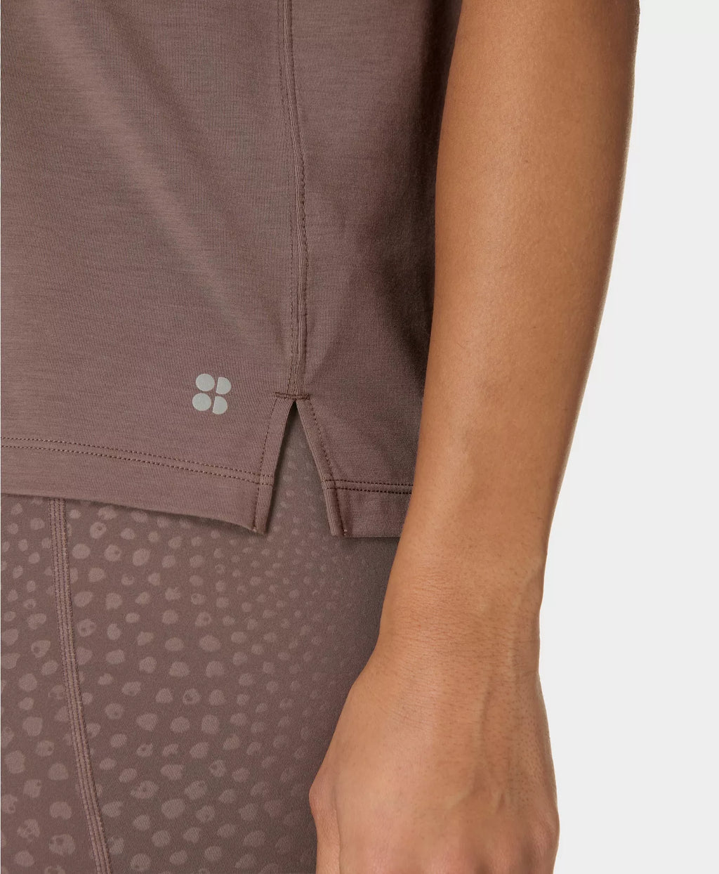 Close-up of a brown athletic outfit with a subtle pattern on a plain background