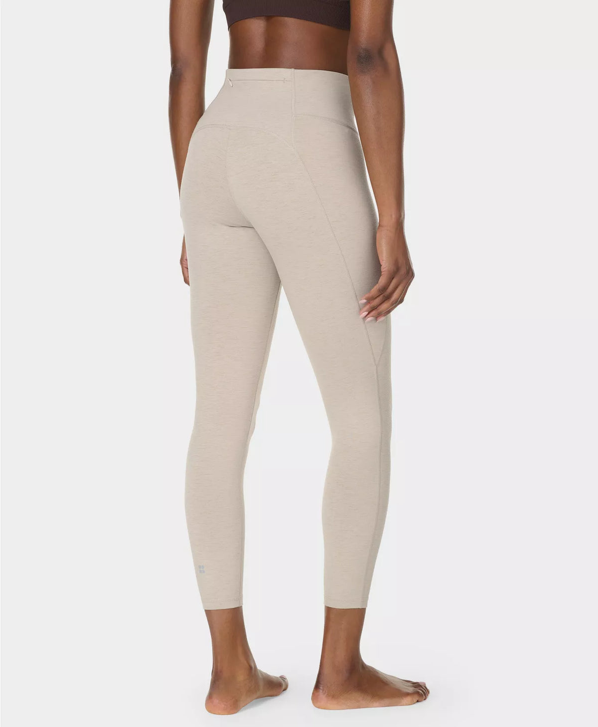 Beige leggings worn by a person on a white background