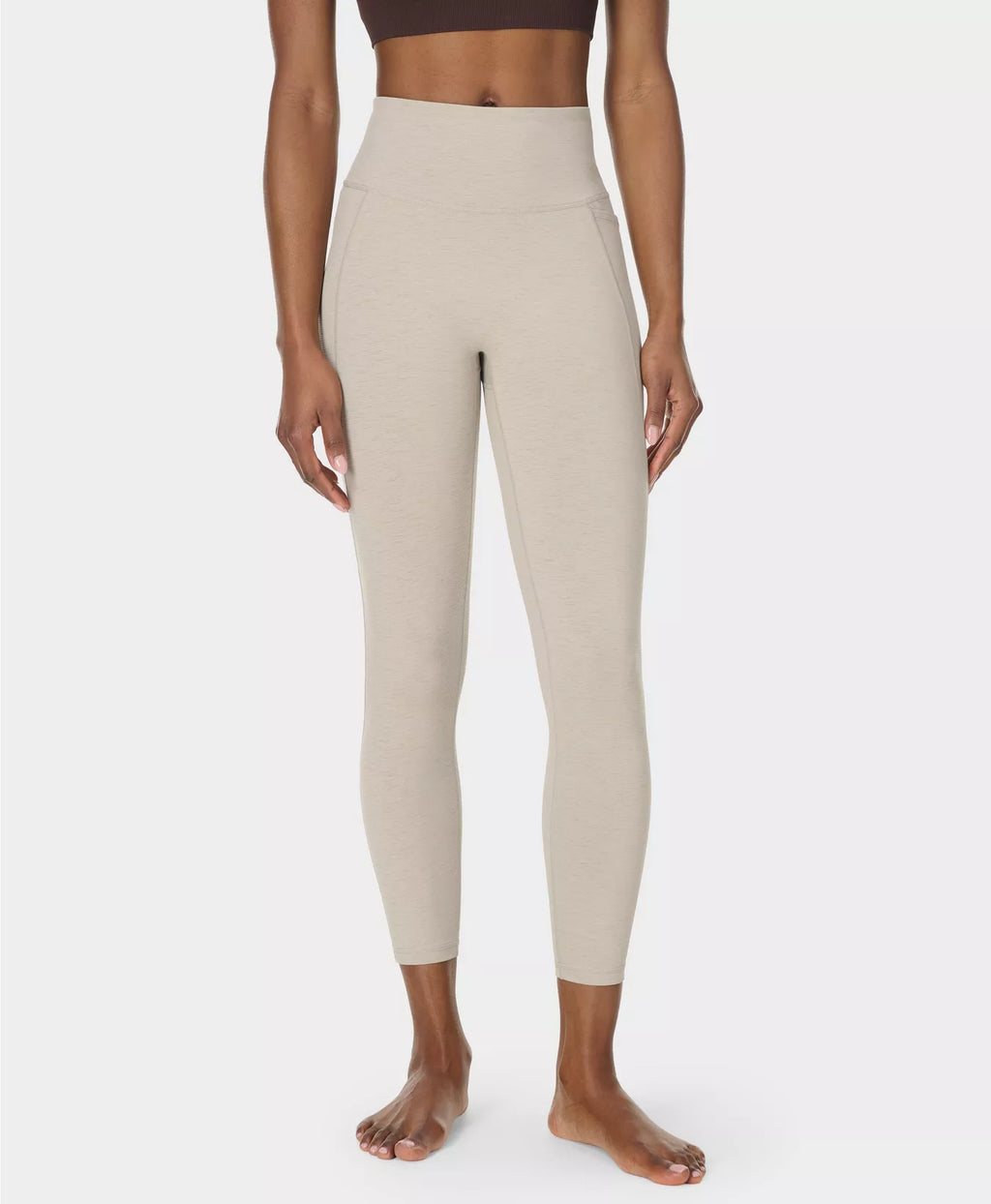 Beige leggings worn by a person on a white background