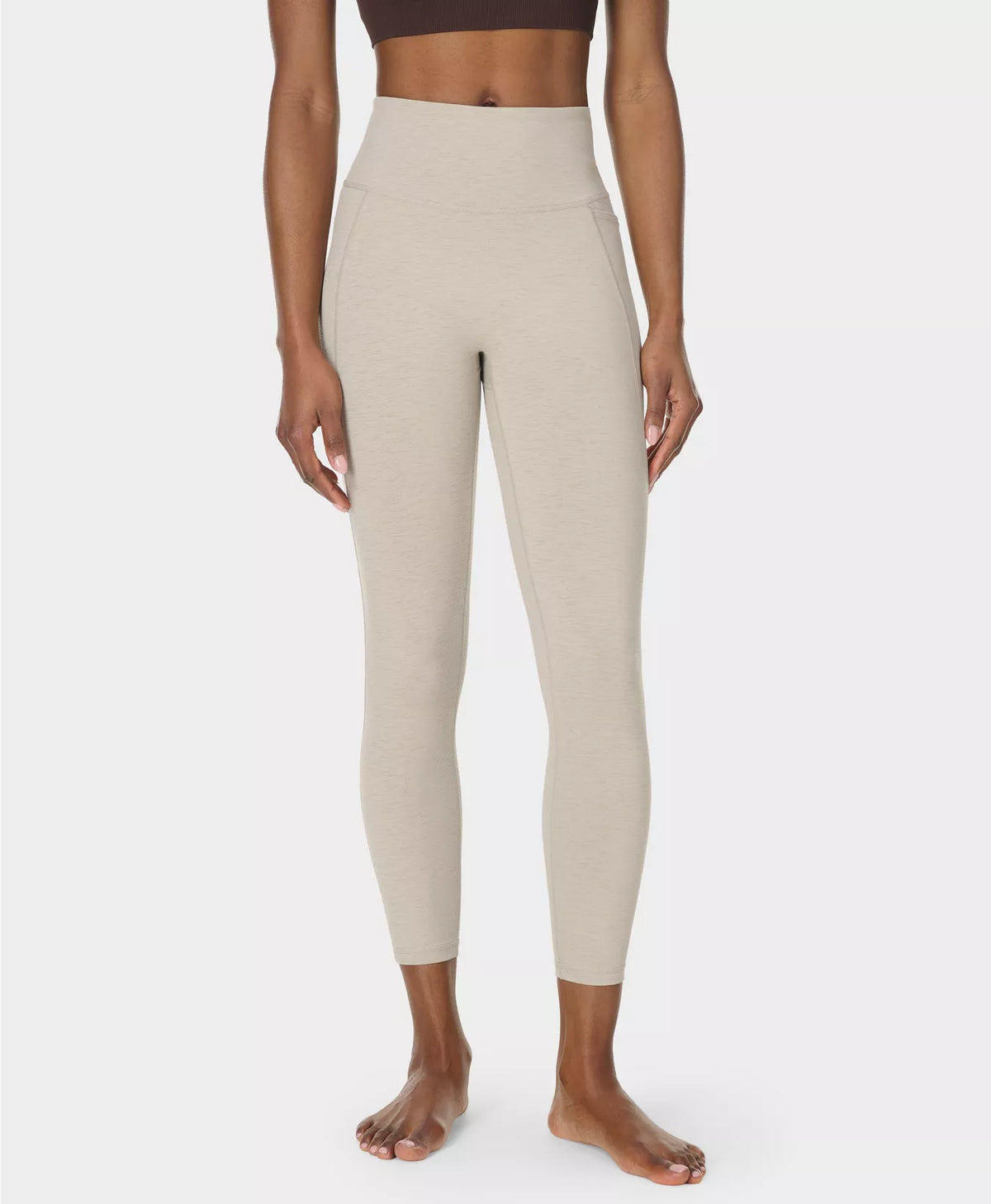 Beige leggings worn by a person on a white background