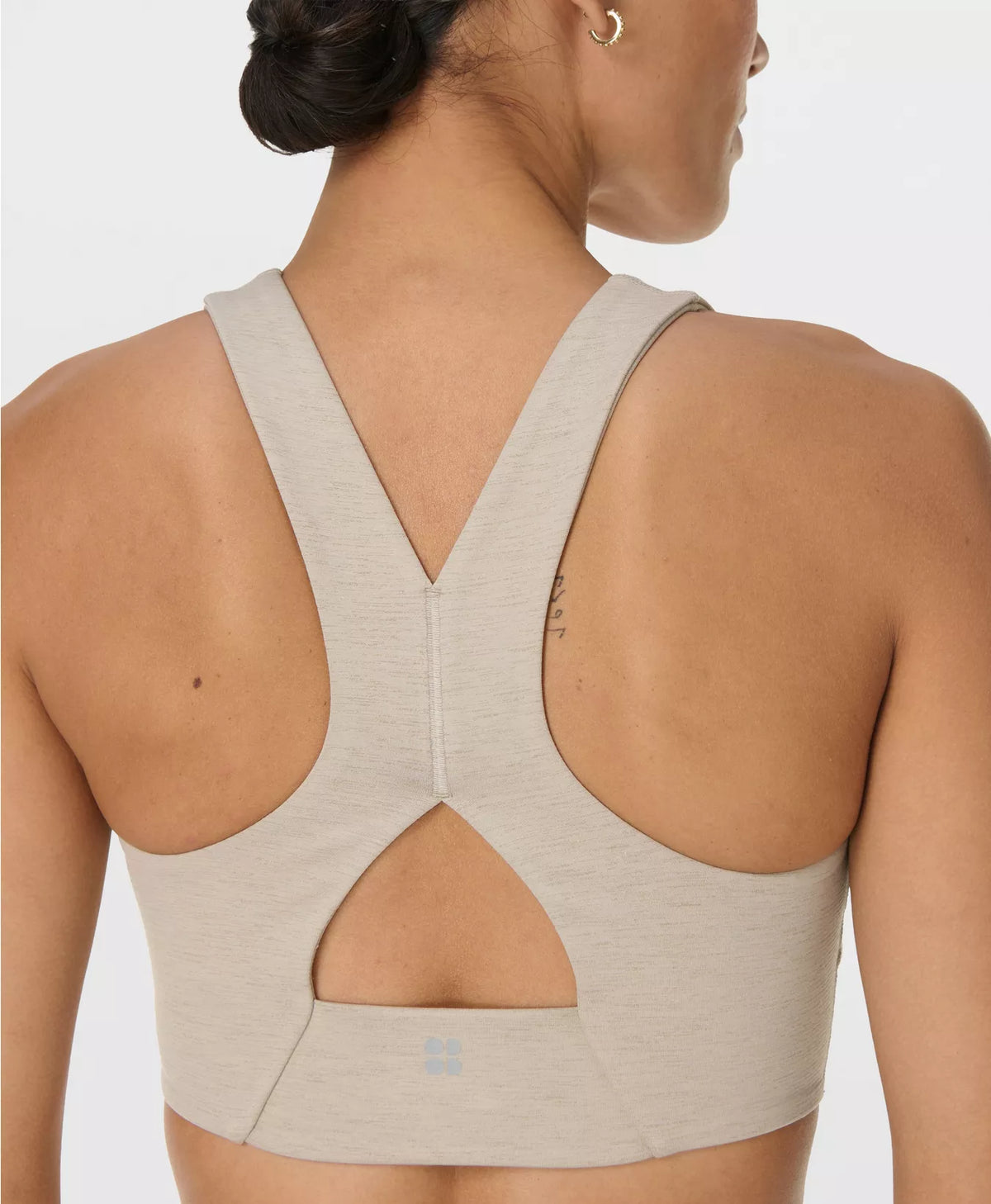Beige sports bra worn by a person on a light gray background