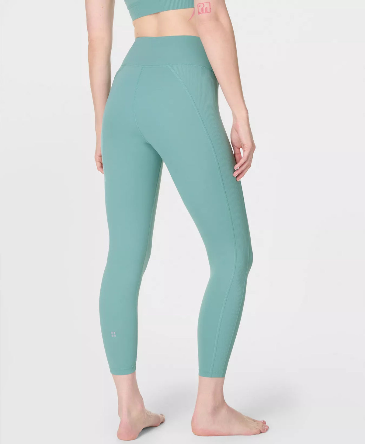 Person wearing teal leggings on a white background