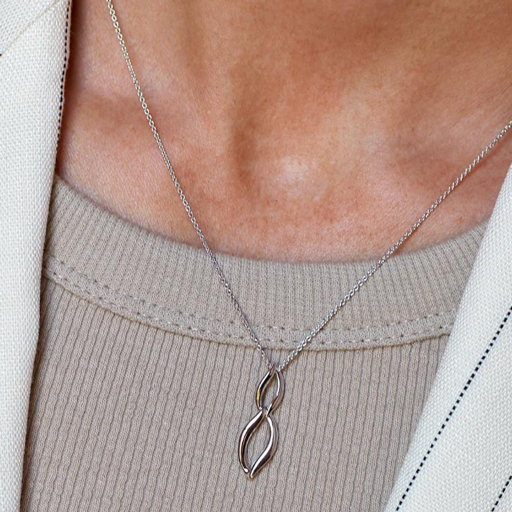 Close-up of Kit Heath Entwine necklace showcasing its elegant double link design on a silver chain, highlighting its fine