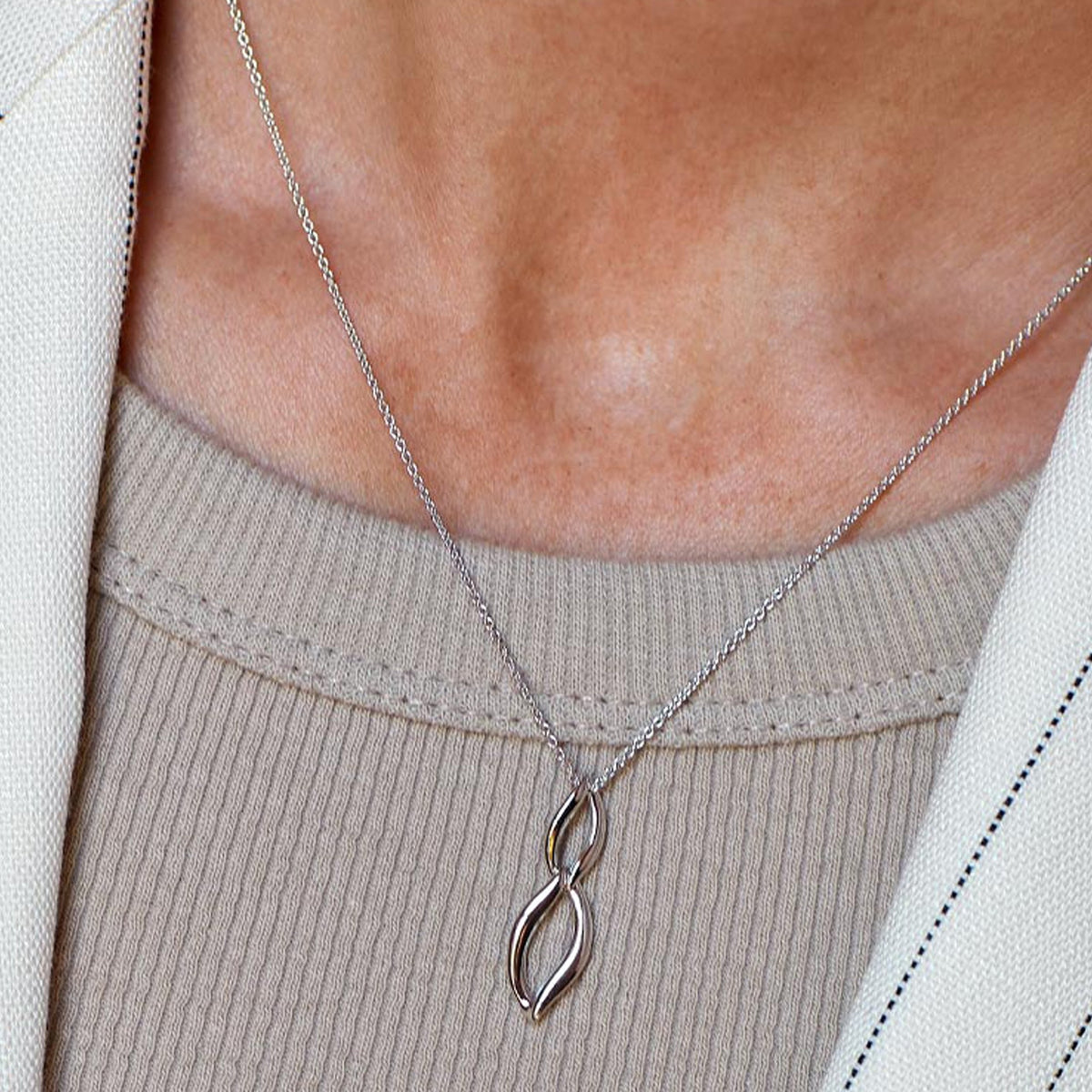 Close-up of Kit Heath Entwine necklace showcasing its elegant double link design on a silver chain, highlighting its fine