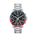 Close-up of BOSS Troper chronograph watch showcasing black dial, stainless steel band, & red/blue bezel.