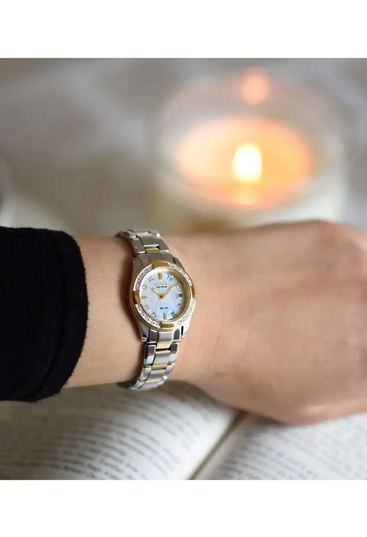 Woman wearing a Citizen Eco Drive watch with diamonds, showcasing its elegance and style. Mother of Pearl face visible.
