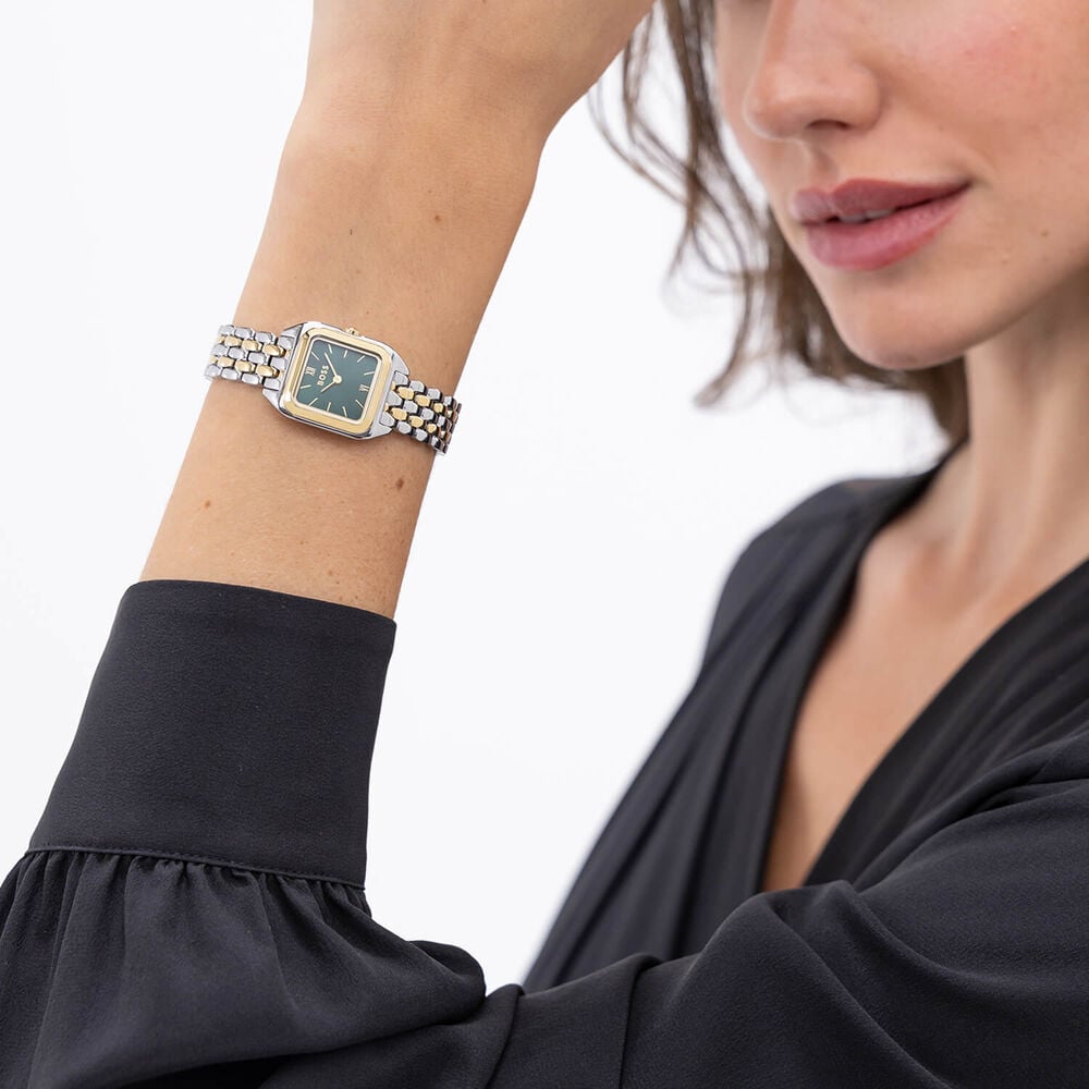 A woman wearing a two-tone watch and a black blouse.
