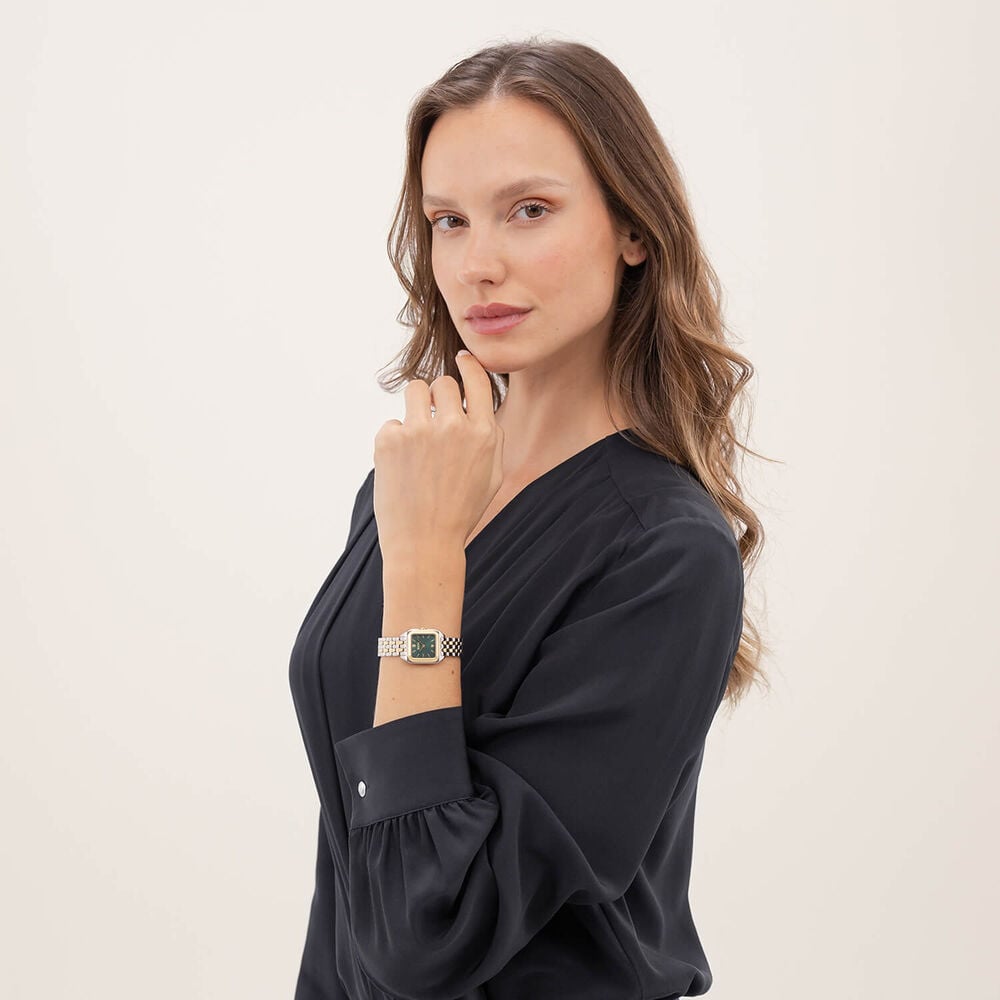 Woman in black blouse wearing a gold watch.

