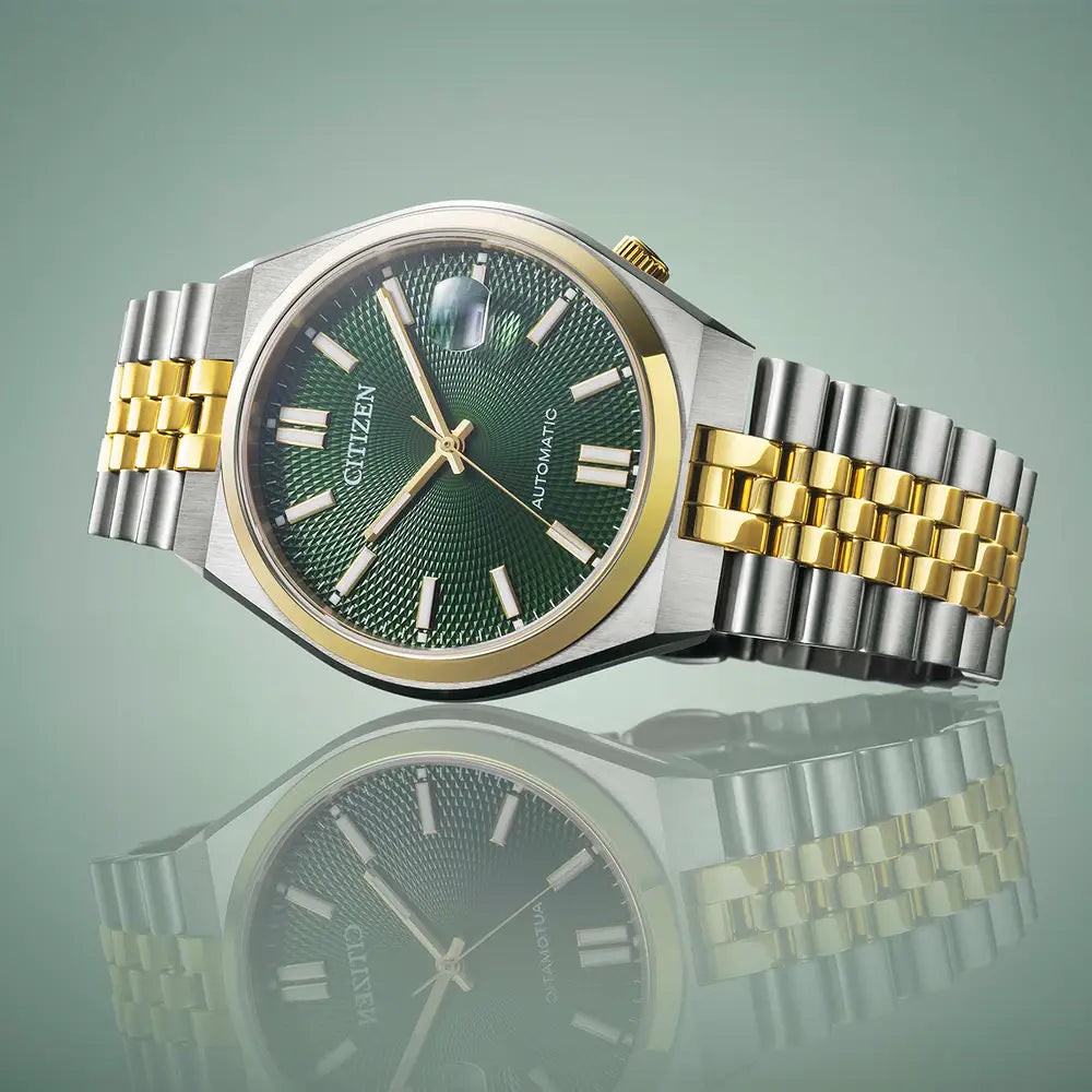 A silver and gold Citizen wristwatch with a green dial.