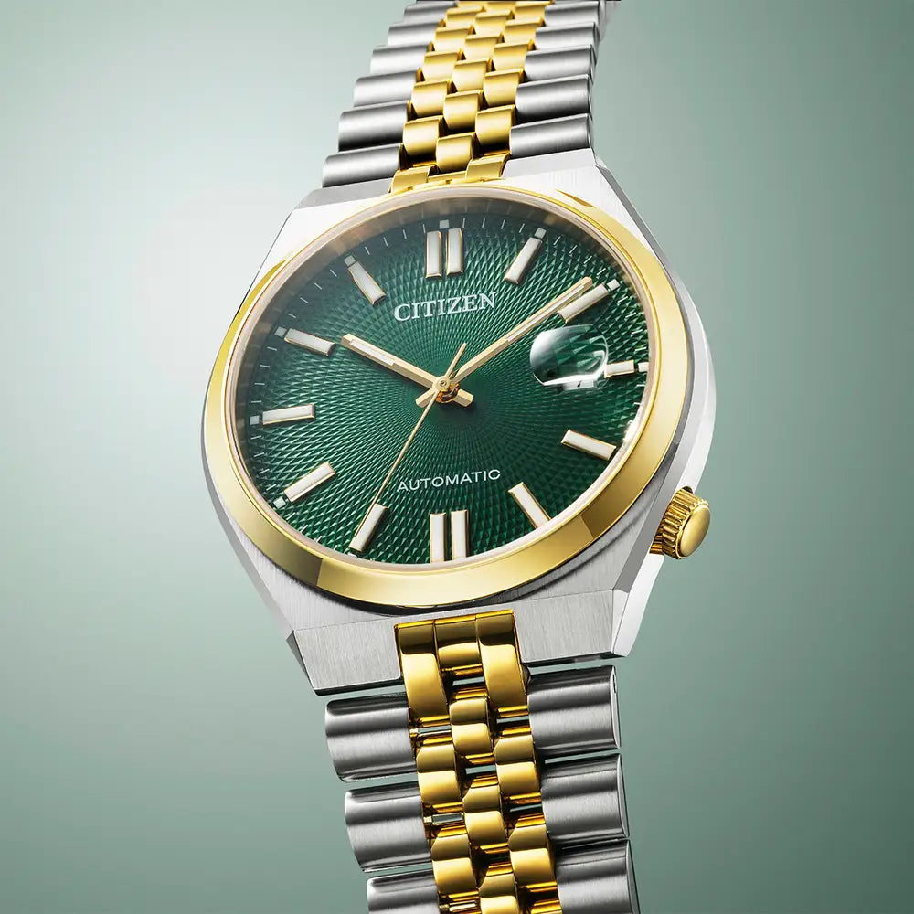 Silver and gold Citizen watch with a green face.
