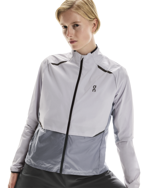 Woman wearing a light lilac jacket with black accents on a white background