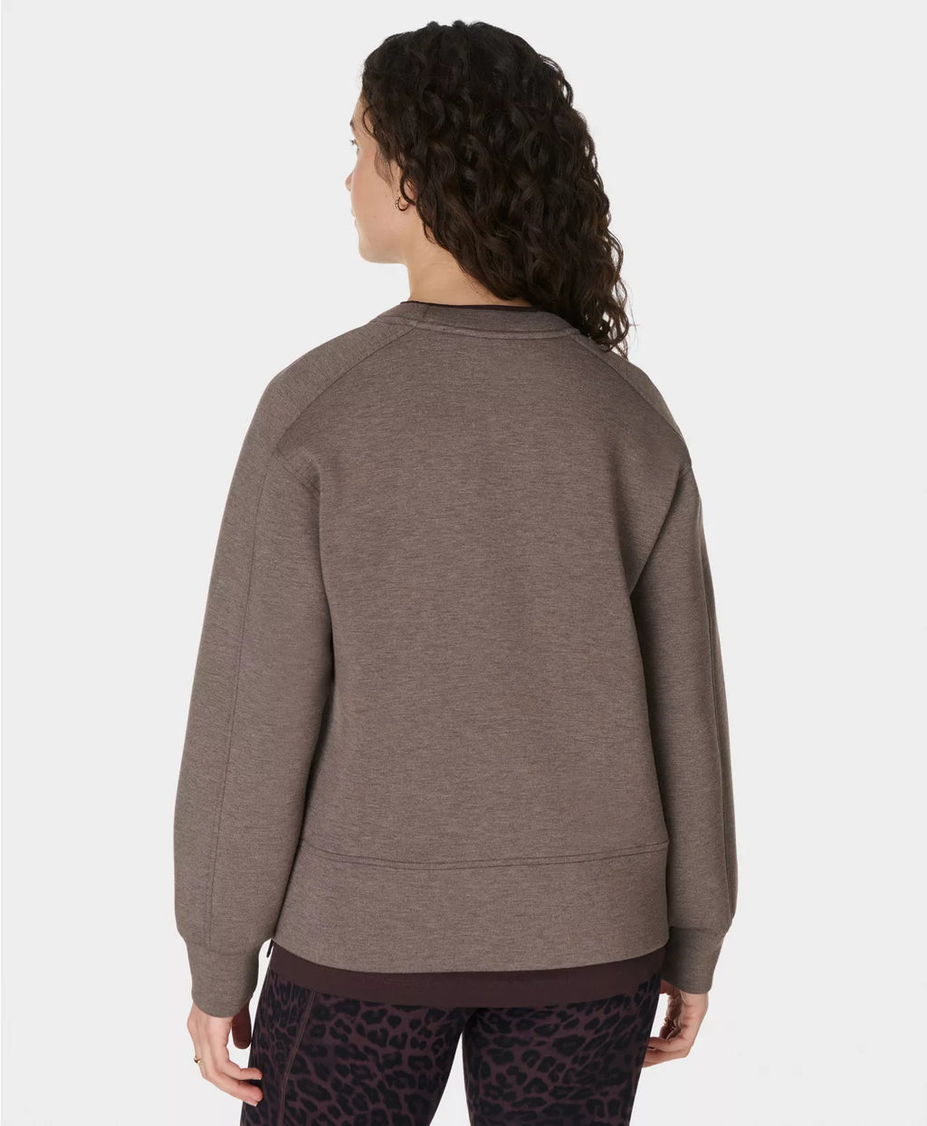 Person wearing a brown sweatshirt on a white background