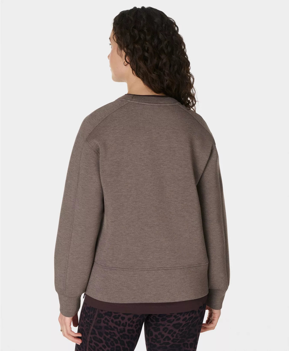 Person wearing a brown sweatshirt on a white background