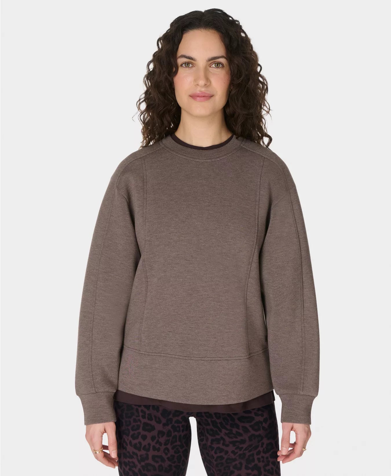 Woman wearing a brown sweatshirt on a white background