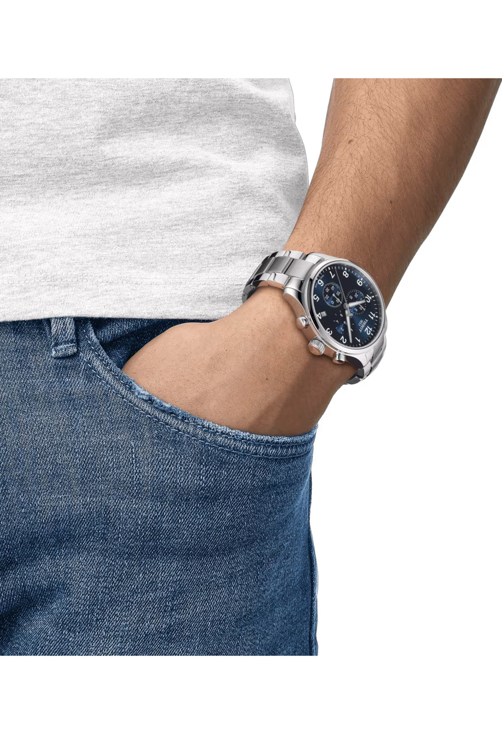Man wearing a Tissot Chrono XL watch with a blue dial and stainless steel bracelet in a casual setting.